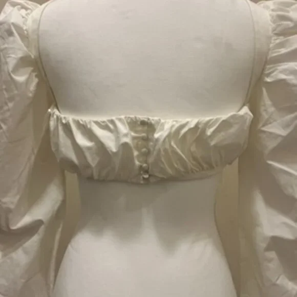 A white crop top with a low neck line, a central bonding detail for structure. - Picture 2 of 3